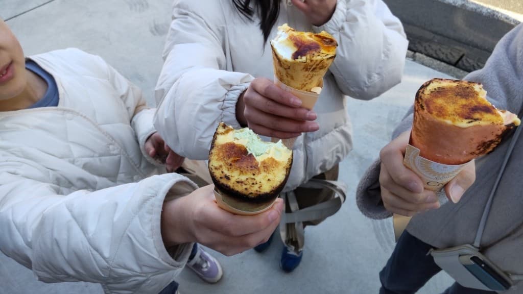 クレープを手に持ち乾杯する様子